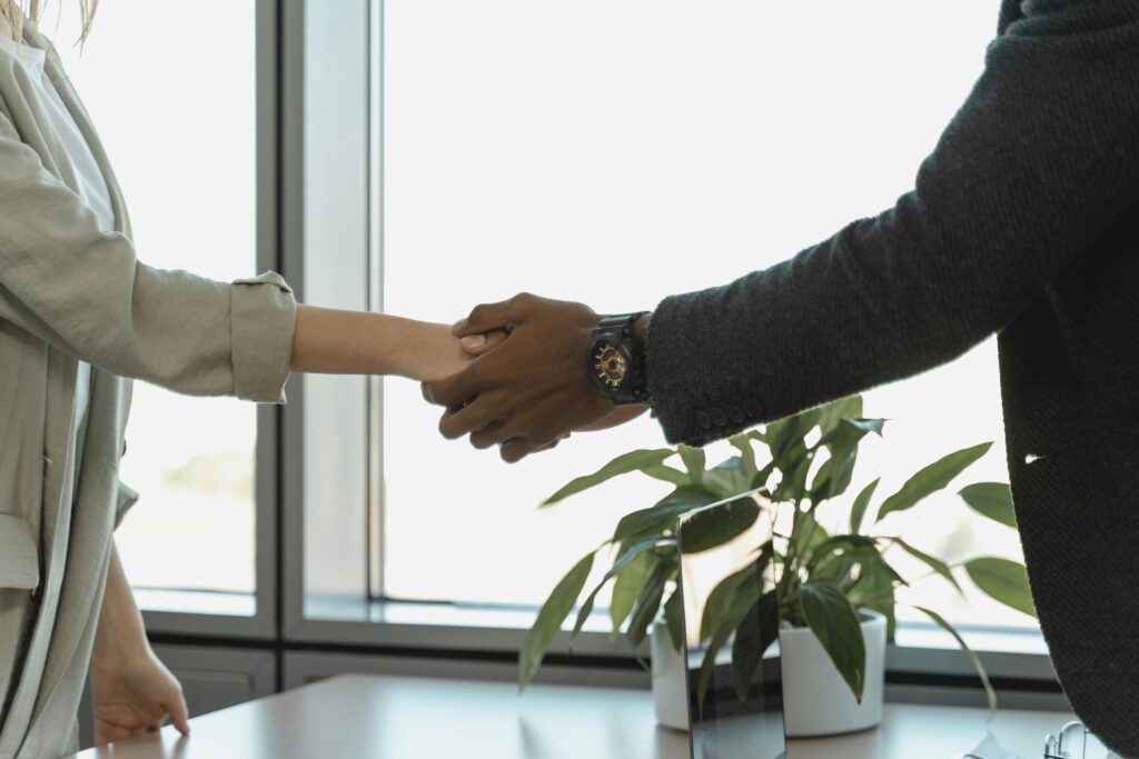 Professional handshake between two colleagues in modern office.